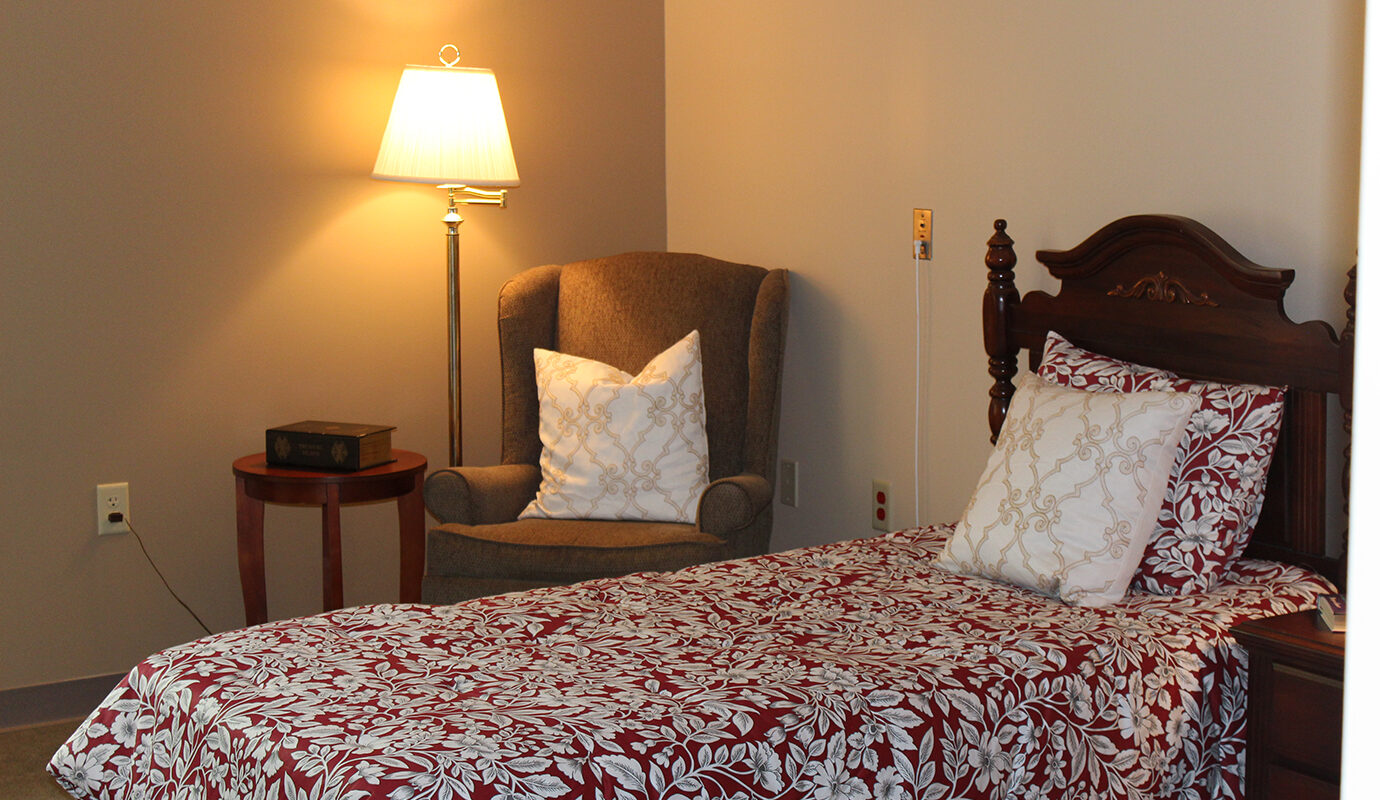 twin size bed next to armchair and lamp