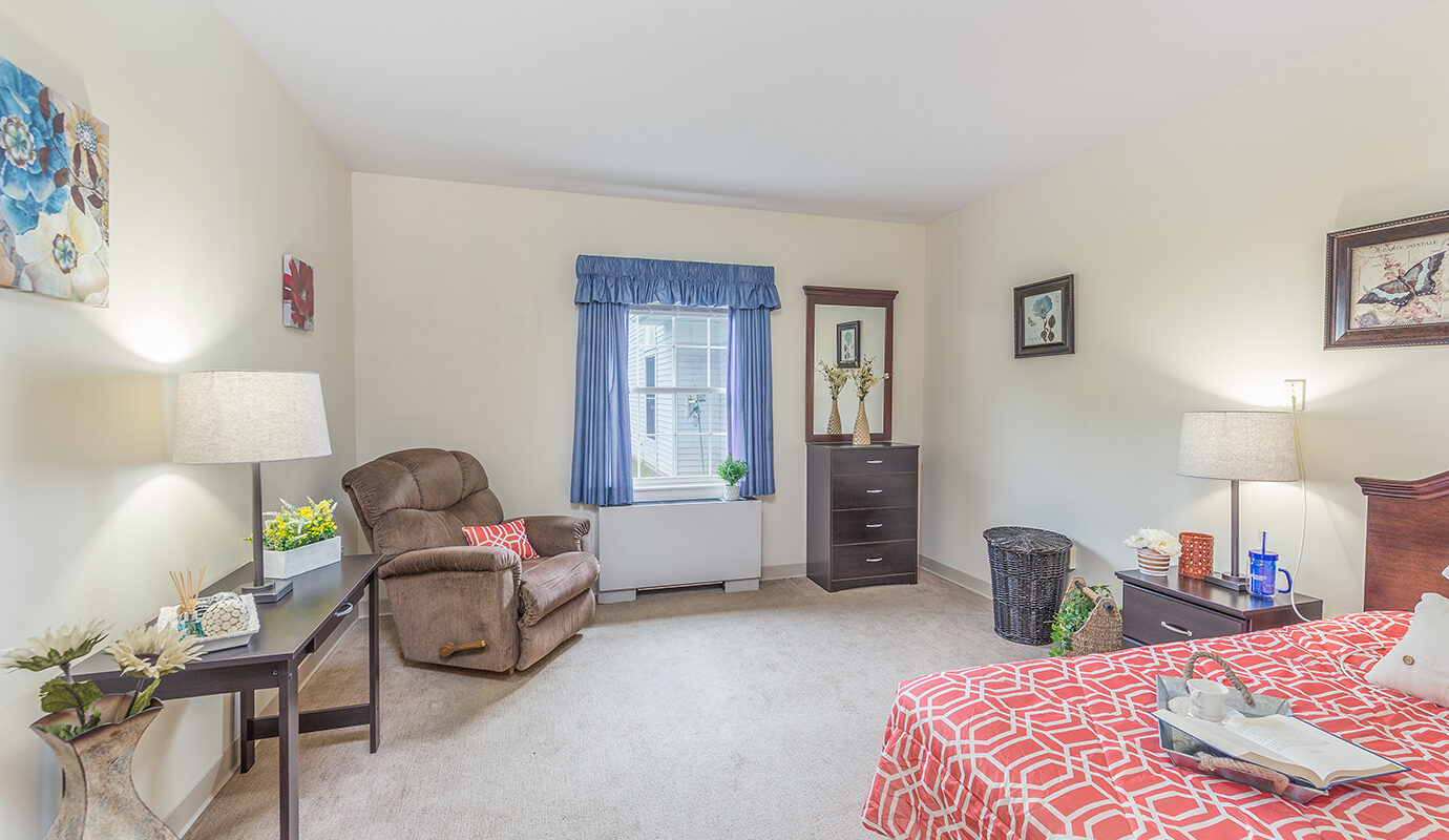 Bedroom with bed, desk, chair and dresser