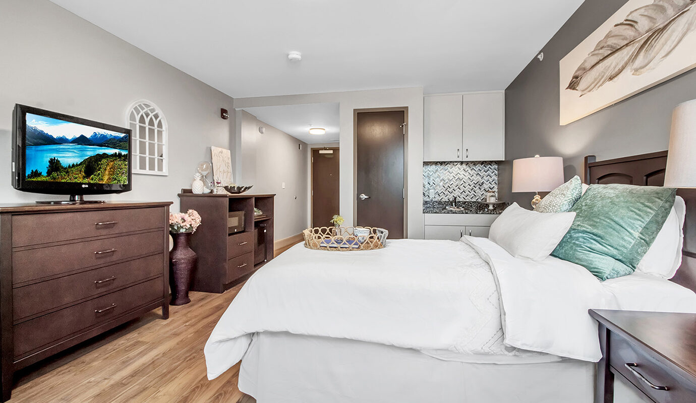 Full size bed with small kitchenette and furniture