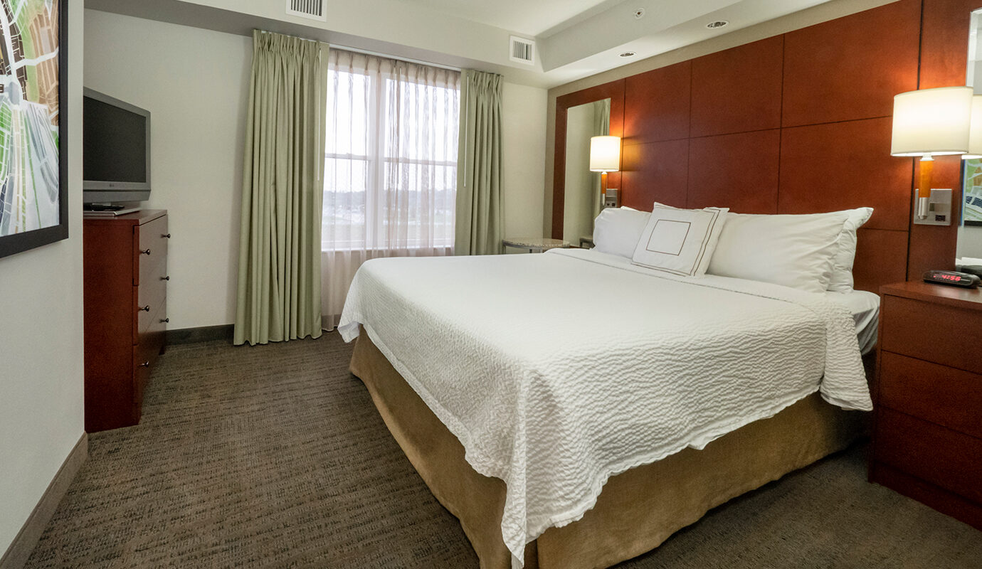 King size guestroom with dress and TV