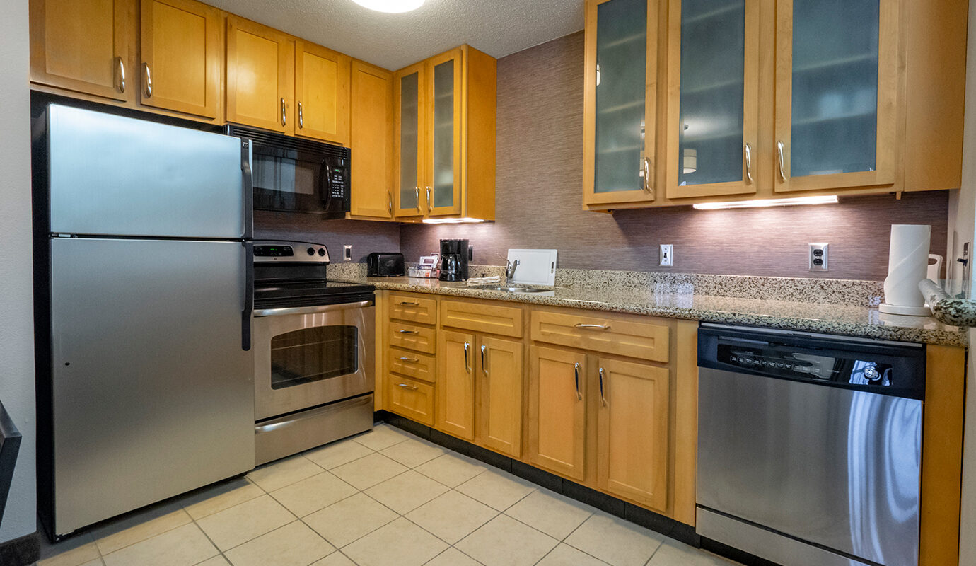 Kitchenette with fridge, stove, counters, and dishwasher