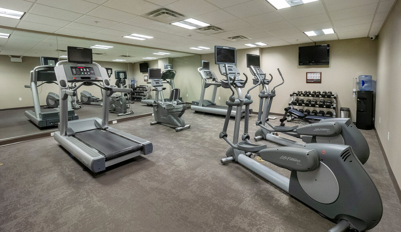 Gym with cardio equipment, TV, and dumbbell station at the Residence Inn in Hazleton, PA
