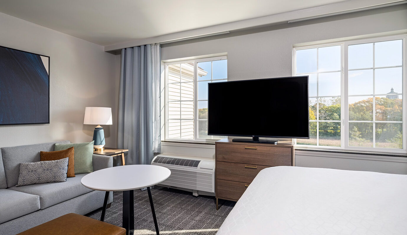 Guest room with bed, couch, dresser, and tv